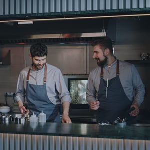 Two chefs collaborating in a professional kitchen