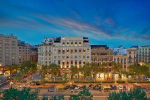 Buitenzicht van het Mandarin Oriental Barcelona aan de Passeig de Gràcia, waarop het luxe hotel in de schemering in het hart van Barcelona te zien is.