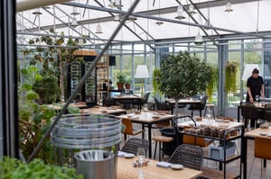 De eetzaal van Restaurant De Kas in Amsterdam, gelegen in de kenmerkende glazen kas.