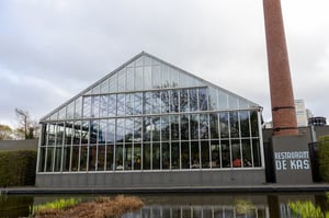 De buitenkant van Restaurant De Kas in Amsterdam, een restaurant in een kas, midden in de natuur.