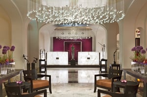 De elegante lobby van Sofitel Legend The Grand Amsterdam, met een luxueuze receptieruimte met moderne kroonluchters en een verfijnd interieurontwerp.